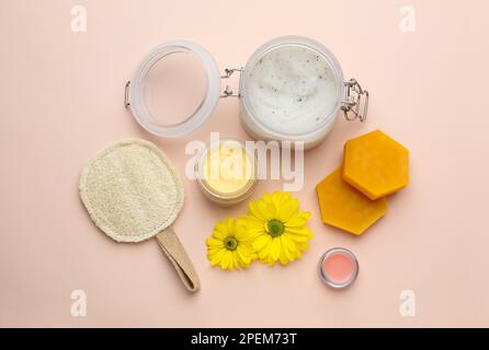 Composizione piana con cera d'api e prodotti cosmetici su fondo beige Foto Stock