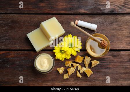 Composizione di posa piatta con cera d'api e prodotti cosmetici su tavola di legno Foto Stock