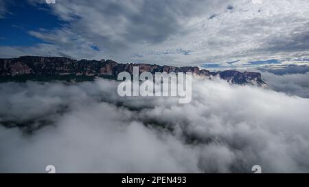 Torreggianti scogliere di pietra arenaria di Auyan Tepui nella luce del mattino nelle nuvole sopra la Gran Sabana, Venezuela Foto Stock