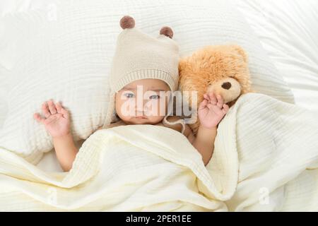 Bella bambina sdraiati sul letto per giocare Foto Stock