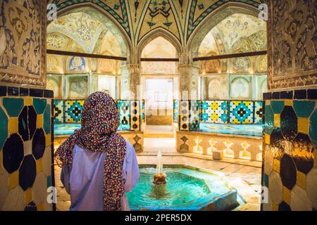 Kashan, Iran - 29th giugno, 2022: Visita turistica Esplora interni e arte nella sala da bagno calda (garmkhaneh) al Sultan Amir Ahmad Bathhouse. Pubblico persiano Foto Stock