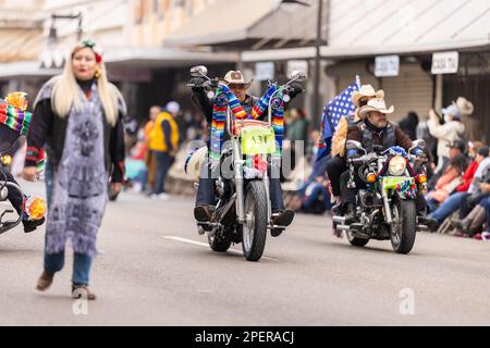 Brownsville, Texas, USA - 26 febbraio 2022: Charro Days Grand International Parade, motociclette a cavallo da uomo che trasportano la bandiera nazionale Foto Stock