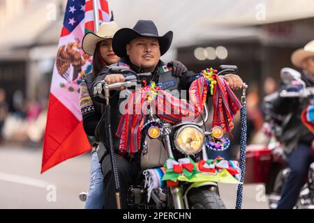 Brownsville, Texas, USA - 26 febbraio 2022: Charro Days Grand International Parade, motociclette a cavallo da uomo che trasportano la bandiera nazionale Foto Stock