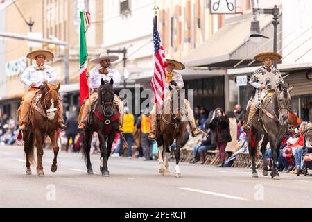 Brownsville, Texas, USA - 26 febbraio 2022: Charro Days Grand International Parade, gli uomini in abiti charro portano il fla nazionale messicano e americano Foto Stock