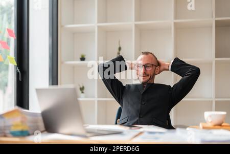 Uomo d'affari rilassato prendere la pausa dal lavoro mettere le mani dietro la testa magra su comoda sedia sente serenità, godere di aria fresca condizionata in ufficio Foto Stock