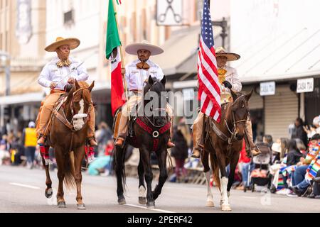 Brownsville, Texas, USA - 26 febbraio 2022: Charro Days Grand International Parade, gli uomini in abiti charro portano il fla nazionale messicano e americano Foto Stock