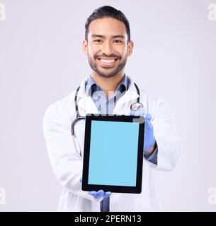 Tablet, schermo verde e ritratto medico isolato su uno sfondo bianco tecnologia per il mockup del servizio di telersalute. Professionista medico o sanitario Foto Stock