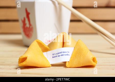 Fortune cookie con frase è un buon momento per finire vecchi compiti. Estrarre il contenitore dal retro Foto Stock