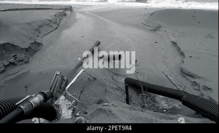 Acque reflue industriali, la conduttura scarica i rifiuti industriali liquidi in mare su una spiaggia cittadina. Le acque reflue sporche scorrono da un tubo fognario in plastica su Foto Stock