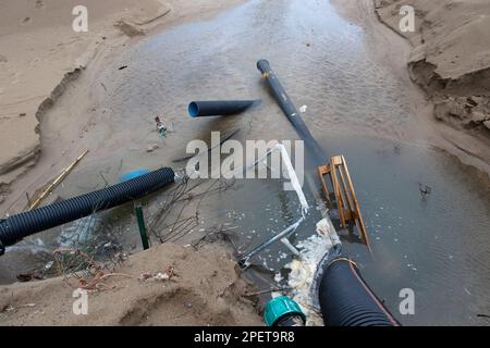 Acque reflue industriali, la conduttura scarica i rifiuti industriali liquidi in mare su una spiaggia cittadina. Le acque reflue sporche scorrono da un tubo fognario in plastica su Foto Stock