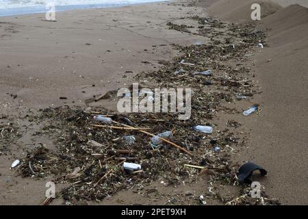 Montagne di spazzatura, vecchie bottiglie di plastica dopo una tempesta, l'onda di surf la getta sulla sabbia del mare della spiaggia della città. Problema ecologico di civilizzazione Foto Stock