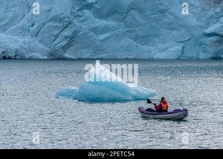 Giovane donna Kayaking Mosevatnet Lago con Folgefelna Glacier sullo sfondo, in visita Norvegia Foto Stock
