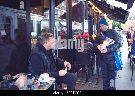 Thomas Henry Skinner l'uomo d'affari inglese e la personalità televisiva che parla con un uomo senza casa, a Soho, Londra 16 02 2023 Foto Stock