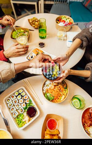 Un gruppo di persone che gustano un pasto insieme in un ristorante Foto Stock