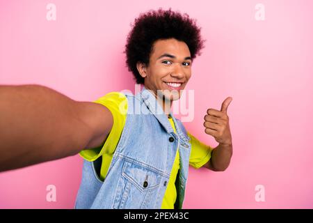 Foto dell'uomo afro positivo indossare abiti retrò trendy pollice su registrazione video streaming isolato su sfondo di colore rosa Foto Stock