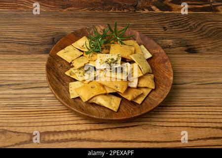 Patatine fritte Pita su piatto di legno, tortillas di grano piccolo, pane piatto croccante con erbe e spezie, snack di grano mediterraneo piccante, patatine fritte Pita Foto Stock