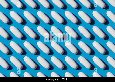 Pop Art Pattern Vitamina in pillole bianche capsula di calcio isolato su sfondo blu, concetto di additivi biologicamente attivi Foto Stock