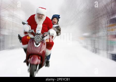 Babbo Natale prende un ragazzo su uno scooter a motore su una strada coperta di neve Foto Stock