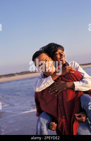 Romantica coppia afro-americana che si diverte in estate sulla spiaggia Foto Stock