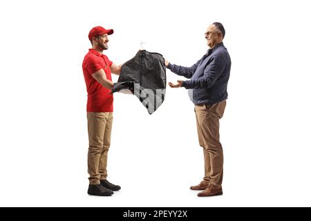 Foto a profilo completo di un addetto alla lavanderia che dà un vestito con una custodia a un uomo maturo isolato su sfondo bianco Foto Stock