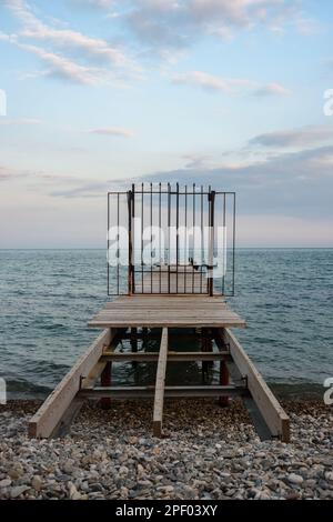 Molo in legno con cancelli in ferro chiusi in mare blu in primavera. Koktebel. Crimea Foto Stock