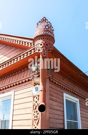 Vecchio downpipe di acqua piovana con ornamento scolpito sulla casa di legno Foto Stock