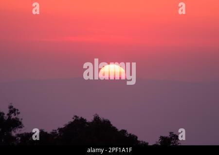 Il paesaggio del sole che sorge risplende di arancione attraverso il cielo. Foto Stock