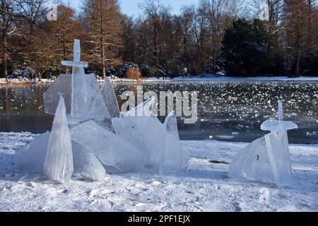 Karlsruhe, Germania - 12 febbraio 2021: Frammenti di ghiaccio accumulati accanto a un piccolo laghetto nei giardini del Palazzo di Karlsruhe in una giornata invernale in Germania. Foto Stock