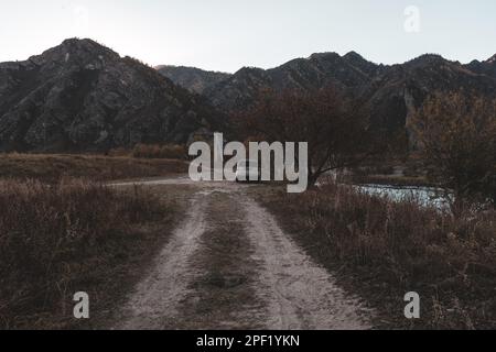 Altai, Russia - 02 ottobre 2022: Una vecchia macchina del marchio 'Honda HR-V' si trova in lontananza dalla strada sotto le montagne e le rocce vicino al fiume Foto Stock