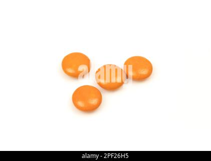 Poche gocce arancioni isolate su sfondo bianco. Caramelle alla menta Foto Stock