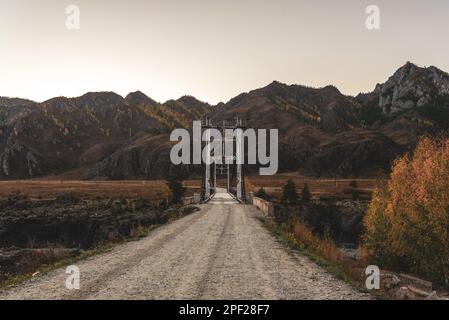 Ponte Oroktoy attraverso il fiume Katun nelle montagne Altai in autunno in Siberia. Foto Stock