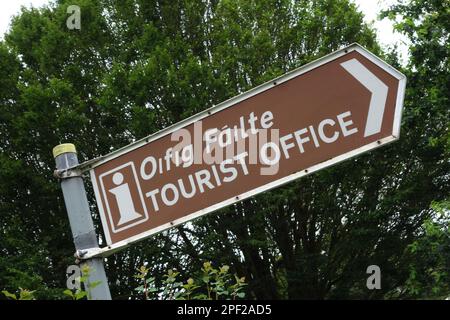 Segnale stradale bilingue che indica l'ufficio turistico di Adare, contea di Kerry, Irlanda Foto Stock