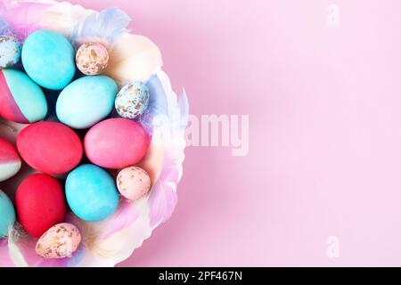 Uova di Pasqua dipinte in cremisi e blu su sfondo rosa con un posto per il testo. Buon concetto di Pasqua. Biglietto d'auguri, spazio copia Foto Stock