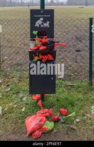 Punto di raccolta sovraffollato per i sacchi di escrezione di cani di fronte a un parco giochi per cani, Baviera, Germania Foto Stock