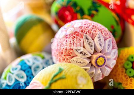 Colorate uova di Pasqua tradizionali con ornamenti floreali, decorazioni in origami e lana di crewel, vista ravvicinata. Foto Stock