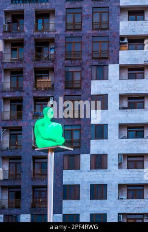 Scultura umana illuminata su un palo di fronte ad un edificio visto dalla cascata di Yerevan, Armenia, Medio Oriente Foto Stock