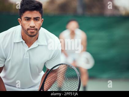 Due giocatori di tennis etnici che tengono racchette e pronti a giocare a gioco di campo. Atleti seri e concentrati insieme in posizione. Giocare a due giocatori competitivi Foto Stock