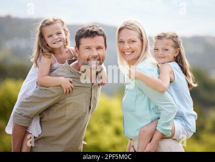 Mi sostengo con l'amore della famiglia. una coppia e le loro due figlie si posano insieme in un parco. Foto Stock