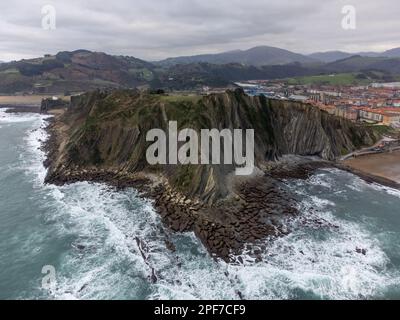 Vista su strati ripidamente inclinati di formazione geologica flysch sulla costa atlantica a Zumaia a bassa marea, Paesi Baschi, Spagna Foto Stock