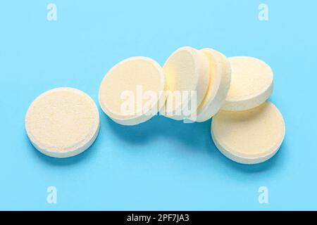 Compresse gialle solubili su sfondo blu Foto Stock