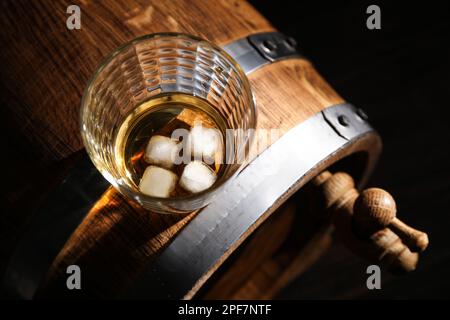 Botte di rovere con bicchiere di whiskey freddo su fondo scuro Foto Stock