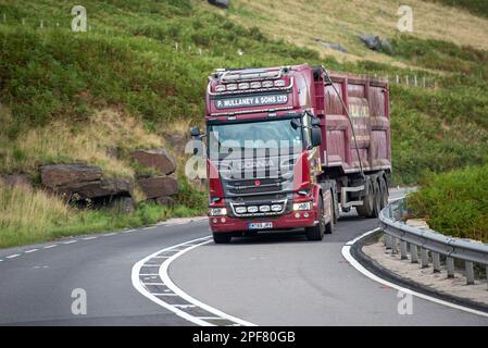 Scania Truck che traina un rimorchio ribaltabile per carichi sfusi affronta una curva in discesa sul Woodhead Pass nello Yorkshire Foto Stock