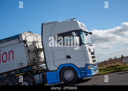 Una Scania di distribuzione di Lomas che tira un rimorchio Fruehauf ribaltabile alla rinfusa fa una curva nella Hope Valley, Derbyshire, Regno Unito Foto Stock