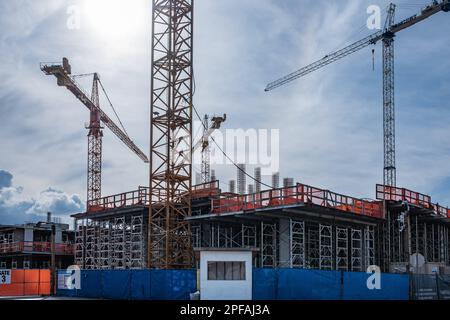 Paesaggio industriale con silhouette di gru d'azione su sfondo cielo suggestivo. Nuovo sviluppo a Vancouver Canada. Alta resistenza in cemento Foto Stock