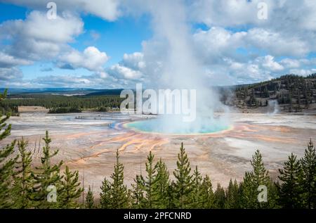 Il vapore che sorge dalle sorgenti termali Grand Prismatic Hot Spring, turisti indistintivi che camminano sul lungomare. Yellowstone National Park, Stati Uniti. Foto Stock