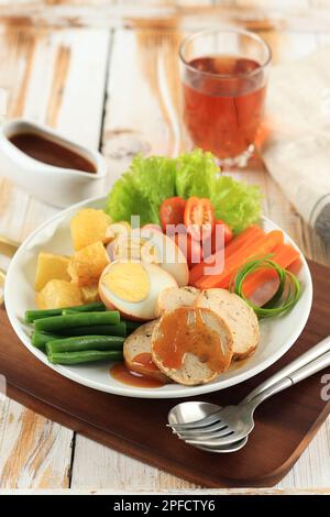 Selat solo Galantin, tradizionale menu Giavanese Indonesiano con influenze europee. Composta da Meatloaf e Steamede Vegetable, con salsa al sugo Foto Stock