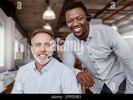 Fornire un'esperienza al cliente supererà le vostre aspettative. Ritratto di due uomini che utilizzano le cuffie in un ufficio moderno. Foto Stock