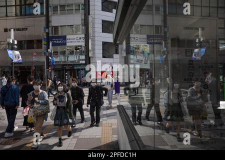 Gli studenti camminano di fronte alla stazione della metropolitana di Ikebukuro a Tokyo. Il Giappone ha allentato le linee guida COVID-19 per indossare la maschera il 13 marzo 2023. Foto Stock