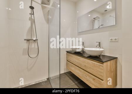 Interior shot di un moderno bagno in primo piano del lavandino armadio con  un bancone lavabo e il grande specchio rotondo vicino alla cabina doccia  Foto stock - Alamy