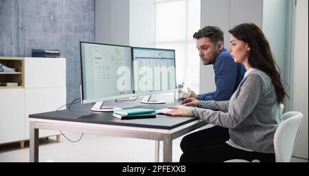 Maschio e femmina conti lavora su computer con fattura al posto di lavoro Foto Stock